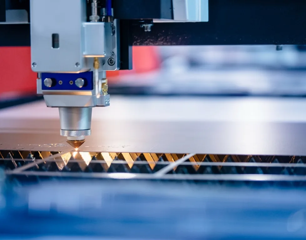 Fiber laser cutting head over a sheet metal bed
